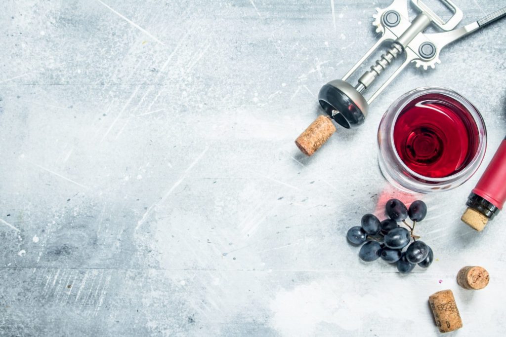 Wine background. A glass of red wine with grapes.